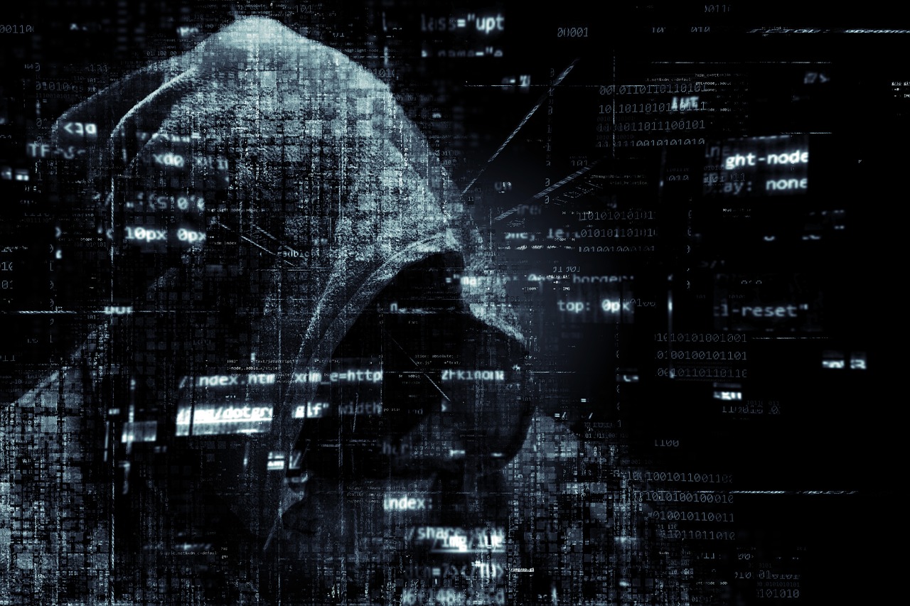 Mysterious person with hood and fragments of computer code floating around the person.