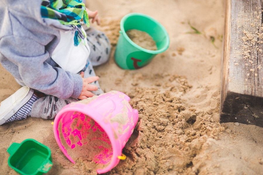 Little boy playing in a sandbox.